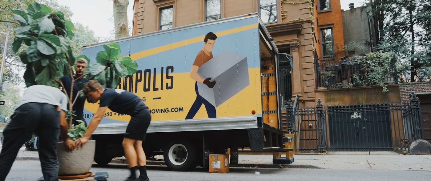 A Nomad crew carrying boxes in front of a moving truck