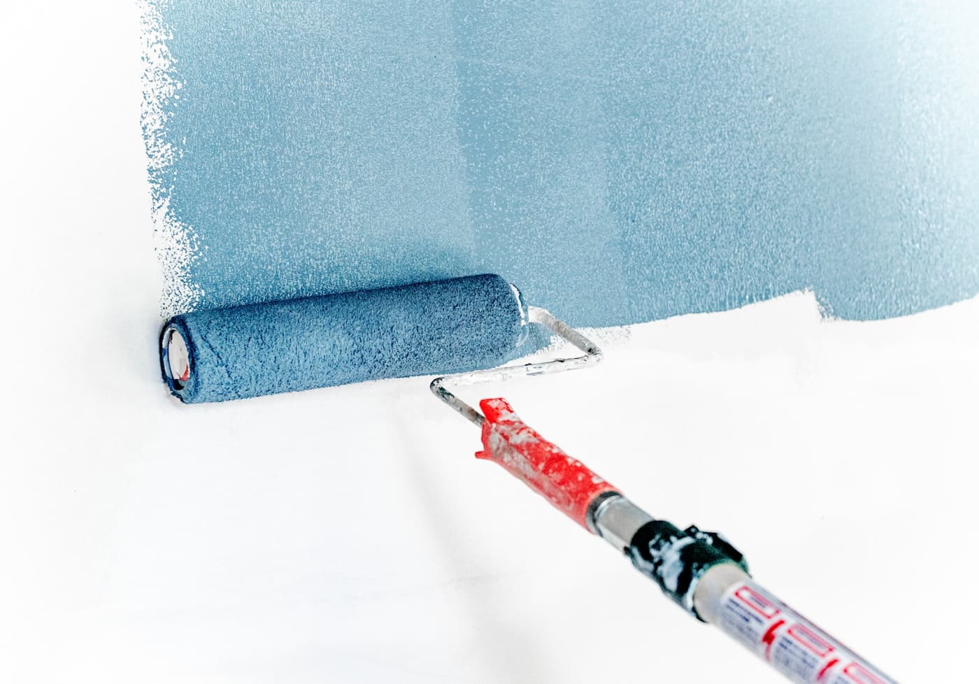 A roller laying down a fresh, even coat of paint on a wall